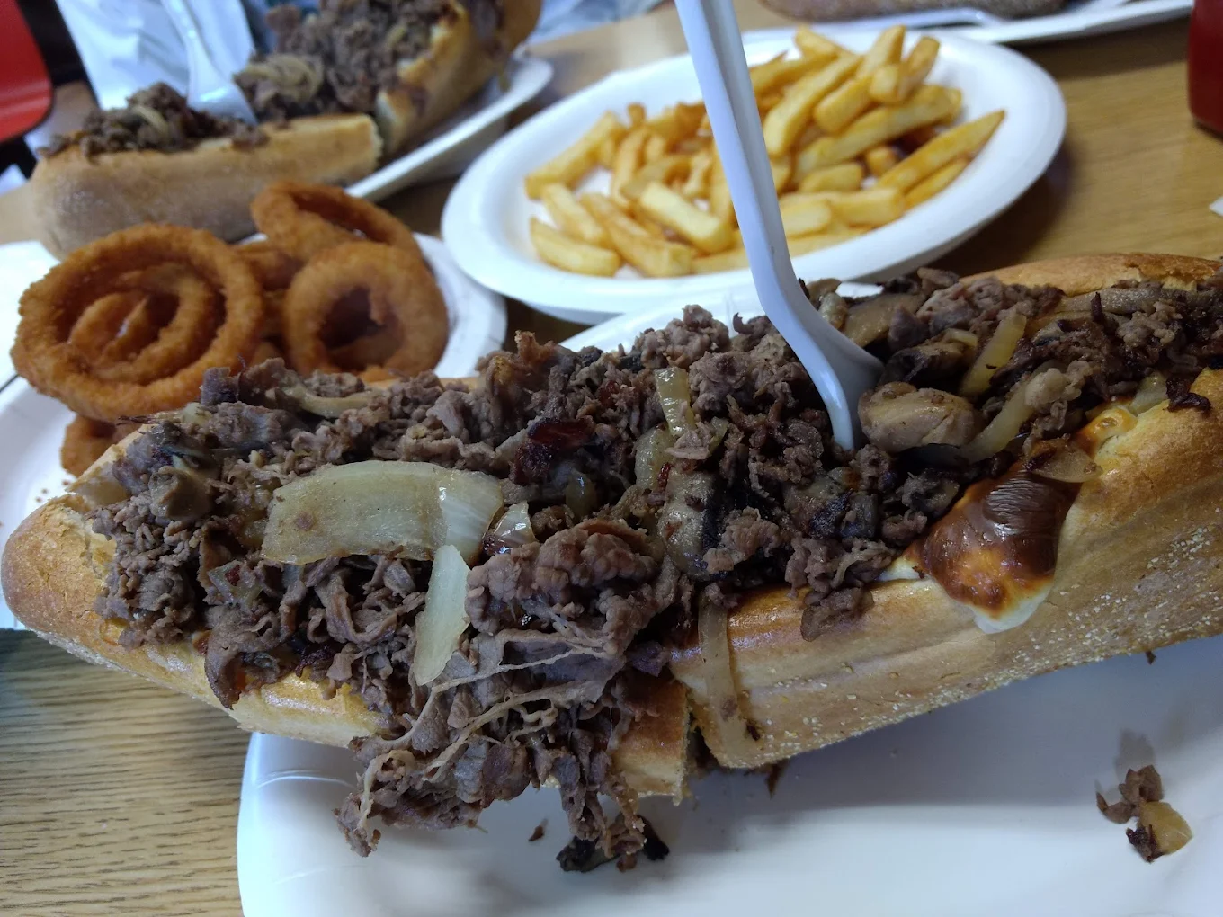 Steak bomb with onion rings and fries